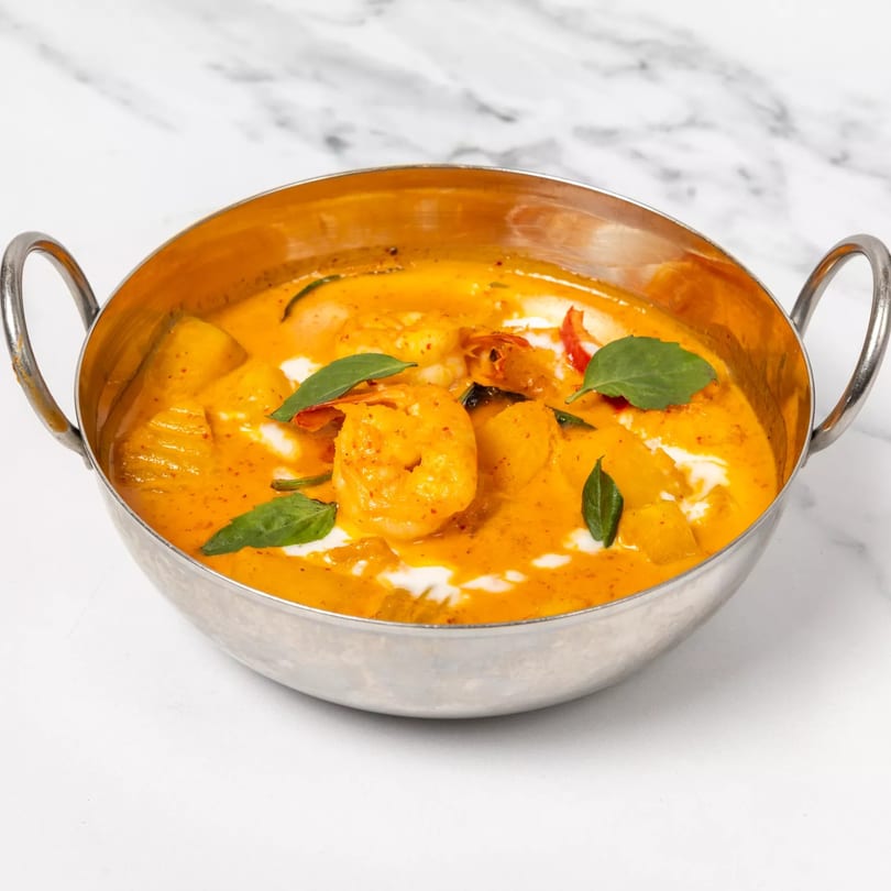 Jai Dee Restaurant's Thai red curry with shrimp, pineapple, and basil in a silver bowl.